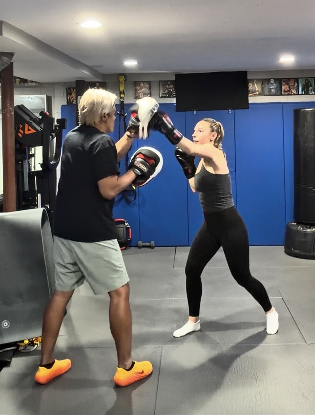 Coach Mike holding focus mitts for a boxing client during Tactician Combat training