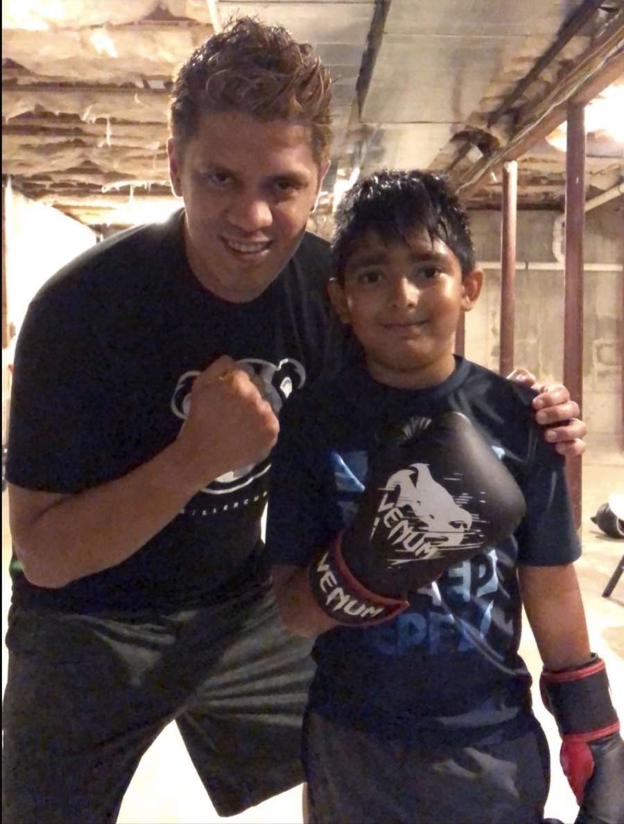 Coach Mike with a young boxer wearing Venum gloves