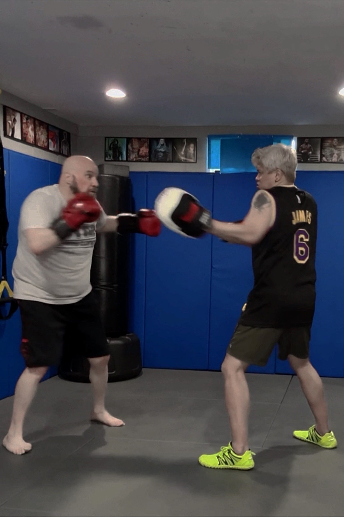 Coach Mike holding boxing pads for a client's striking session at Wolf's Den