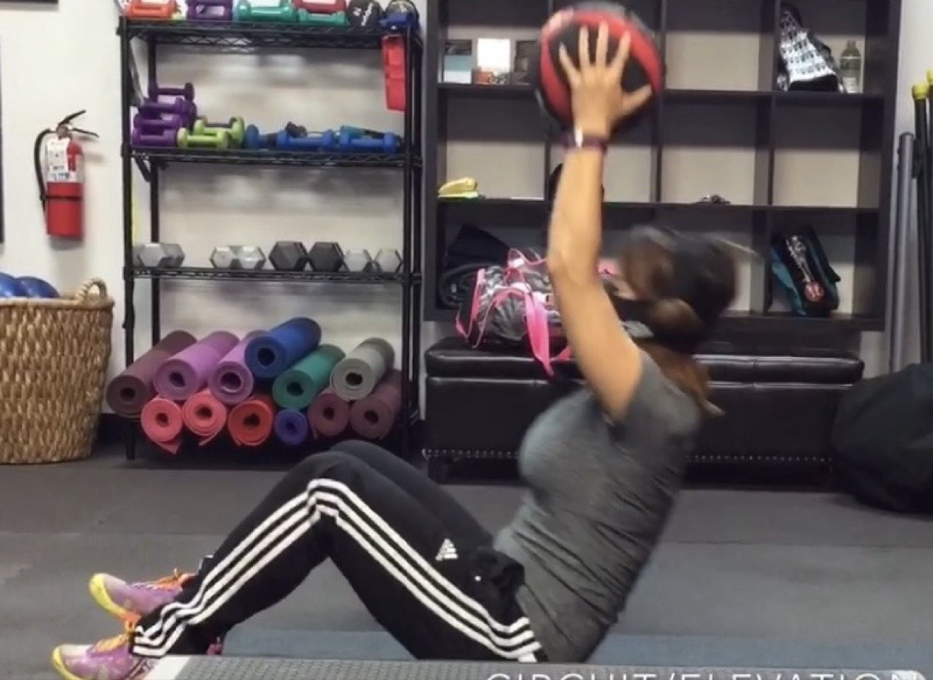 Client performing a medicine ball core exercise during a training session